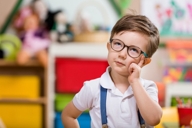 Young child thinking with glasses on